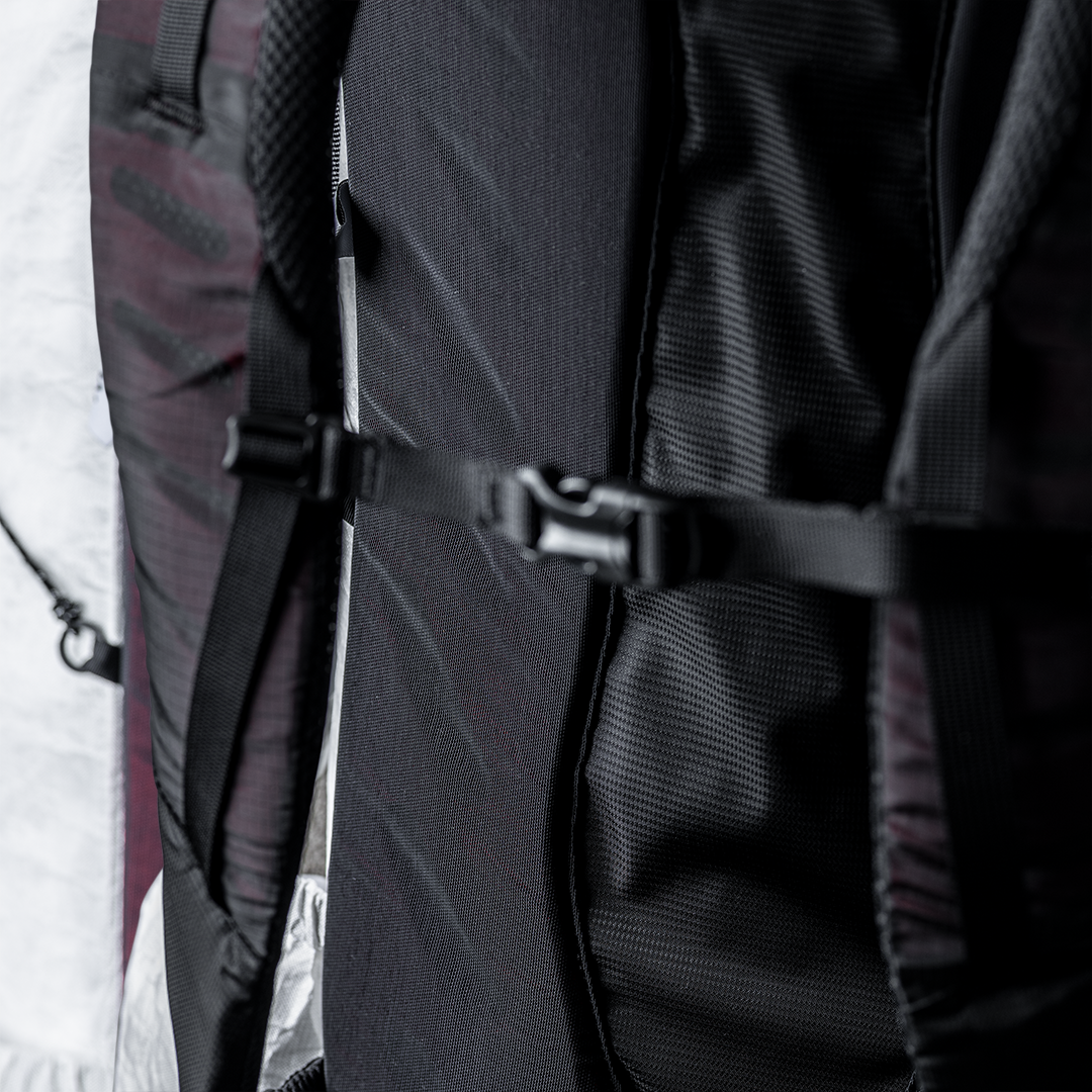 Close-up view of the sternum strap buckled across the back panel and shoulder harness of the Outdoor Vitals CS40 Ultra Backpack.