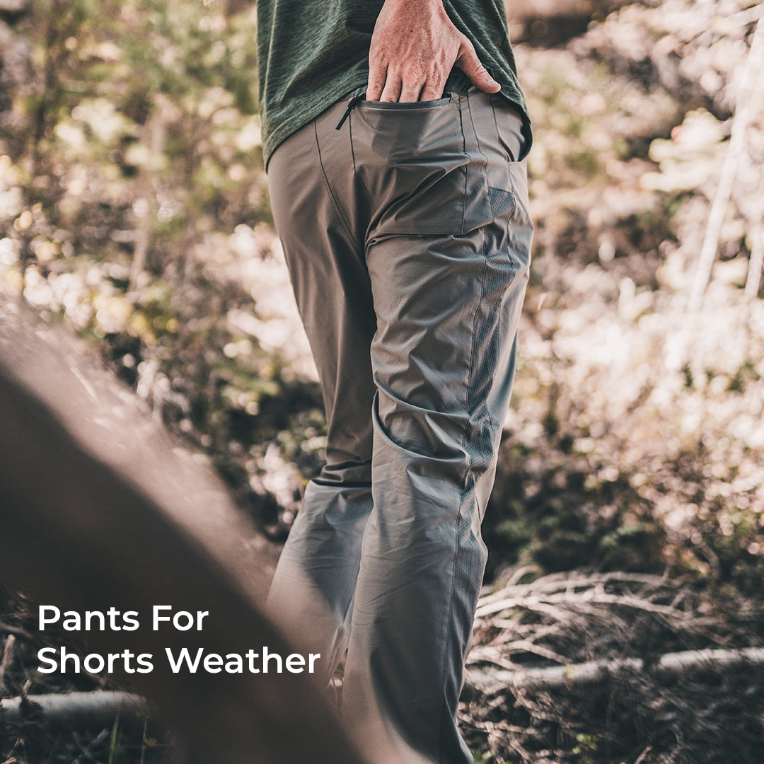 A person outdoors in a wooded setting wearing gray hiking pants 'Pants For Shorts Weather' overlaid in the lower left.