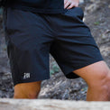 A close-up of a person wearing Outdoor Vitals Skyline Trail Shorts on an outdoor trail.
