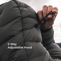 Close-up of a person adjusting the drawstring hood of a dark gray puffer jacket, with white text overlay reading '2-Way Adjustable Hood'.