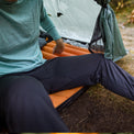 Close-up of a camper sitting in a tent wearing Outdoor Vitals thermal leggings.