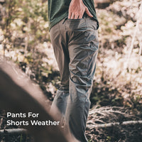 A person outdoors in a wooded setting wearing gray hiking pants 'Pants For Shorts Weather' overlaid in the lower left.