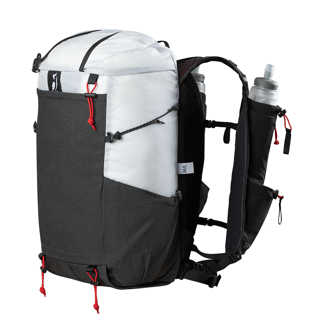 45 degree perspective view of the Outdoor Vitals Skyline 30 Fastpack showcasing the large front stretch-mesh pocket, side compression cording, vest-style shoulder straps with a soft flask inserted, and bottom gear attachment cords.