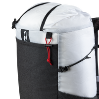 Close-up product detail of the Outdoor Vitals Skyline 30 Fastpack top section, highlighting the roll-top closure strap, brand logo patch, mesh front pocket trim, and side compression cord adjustment system.