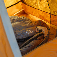 side view of woman sleeping inside down sleeping bag in her tent