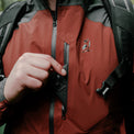 Close-up of a person wearing a waterproof jacket with a zippered chest pocket