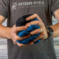 Man compressing a jacket into a tight ball to show packability.