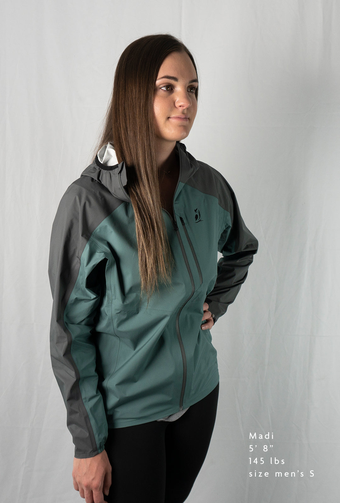 Fit-reference studio shot of a female model wearing a Tushar Rain Jacket in a men's size small.