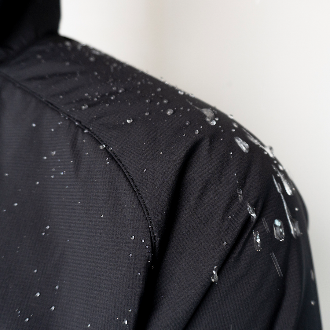 Close-up of the Outdoor Vitals Vario Jacket shoulder with water droplets beading on the fabric