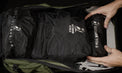 Overhead view of hands placing packing cubes and accessory pouches into the fully unzipped main compartment of the Outdoor Vitals KotaUL Ultralight Travel & Adventure Backpack.