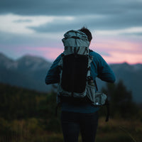 Adventurer in front of a mountain vista wearing the Shadowlight Ultralight Backpack