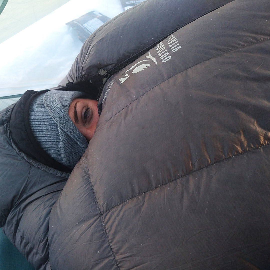 close view of woman peeking out of her lofty down sleeping bag