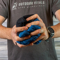 Man compressing a jacket into a tight ball to show packability.